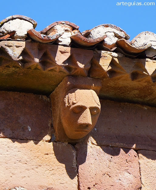 Cabeza humana en uno de los canecillos del ábside